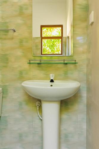 a white sink in a bathroom with a mirror at Villa South view Residence in Galle