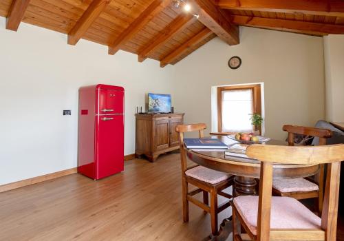 a kitchen with a table and a red refrigerator at La mansardina in Aosta
