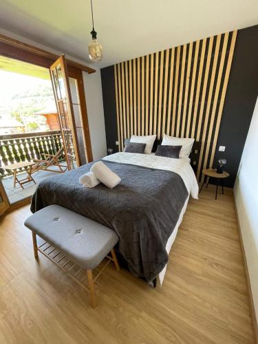 a bedroom with a large bed and a balcony at Appartement cocooning à Charmey in Charmey