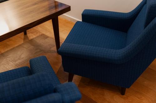 two blue chairs sitting next to a wooden table at 博多の旅籠 すノや in Fukuoka