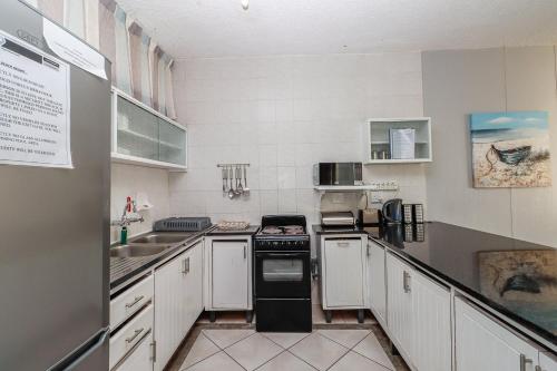a kitchen with white cabinets and a black stove top oven at Seagull 507 in Margate
