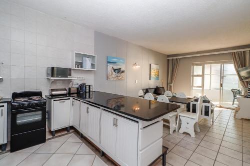 a kitchen with white cabinets and a black appliances at Seagull 507 in Margate