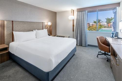 a hotel room with a bed and a desk and a window at Holiday Inn Dublin - Pleasanton by IHG in Dublin