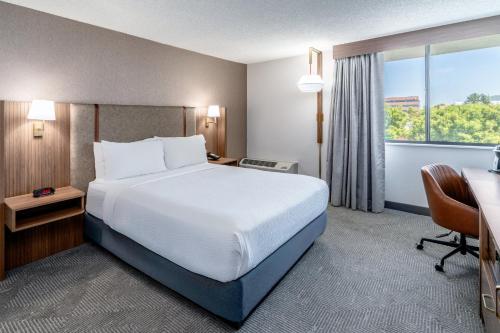 a hotel room with a bed and a desk and a window at Holiday Inn Dublin - Pleasanton by IHG in Dublin
