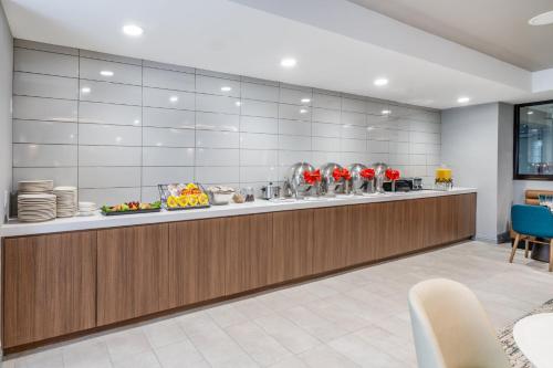 a buffet line in a restaurant with red flowers at Holiday Inn Dublin - Pleasanton by IHG in Dublin