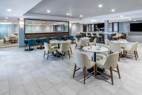 a restaurant with tables and chairs and a bar at Holiday Inn Dublin - Pleasanton by IHG in Dublin