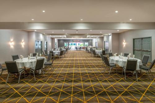 a banquet hall with white tables and chairs at Holiday Inn Dublin - Pleasanton by IHG in Dublin