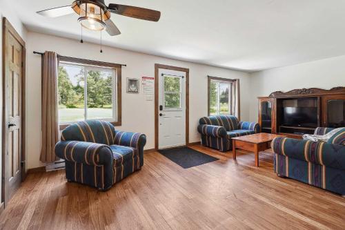 a living room with two chairs and a flat screen tv at Le Mystic - Lake Taureau in Saint-Michel-des-Saints
