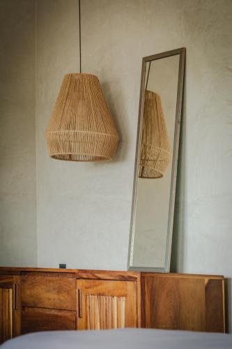 a mirror on top of a dresser with a lamp at MUUN Beach Club in Ciudad del Carmen
