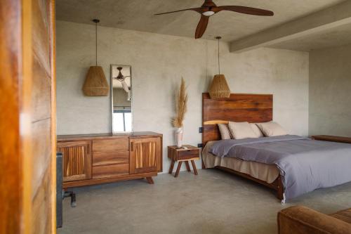 a bedroom with a bed and a dresser and a fan at MUUN Beach Club in Ciudad del Carmen