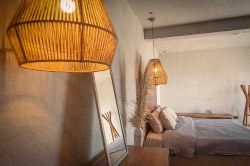 a bedroom with a bed and two lamps and a mirror at MUUN Beach Club in Ciudad del Carmen
