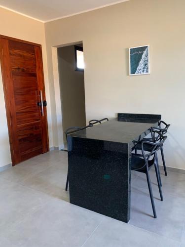 a black table and chairs in a room with a door at ALIZE CUMBUCO in Cumbuco