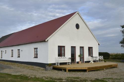 a large white building with a red roof at The farmhouse at Pilgården in Simrishamn