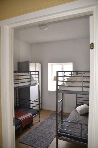 a room with three bunk beds and a window at The farmhouse at Pilgården in Simrishamn