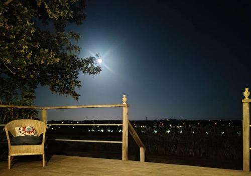 a chair sitting on a deck at night at The farmhouse at Pilgården in Simrishamn