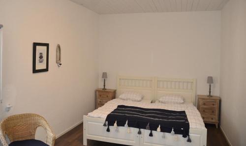 a bedroom with a white bed and two night stands at The farmhouse at Pilgården in Simrishamn