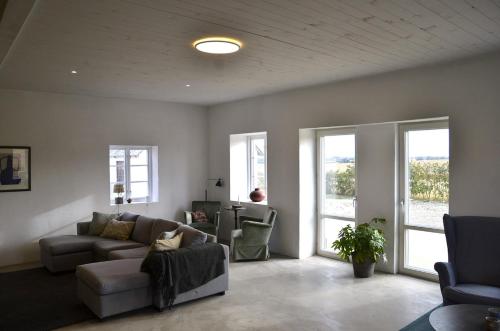 a living room with a couch and chairs and windows at The farmhouse at Pilgården in Simrishamn