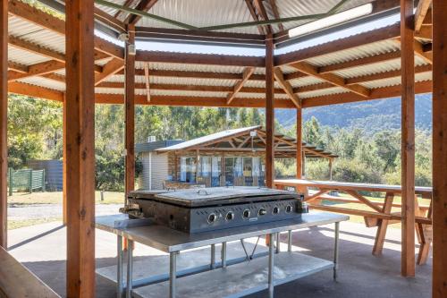 an outdoor kitchen with a grill in a pavilion at The Grampians Motel in Halls Gap