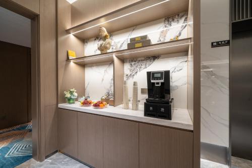 a room with a counter with a coffee maker on a shelf at Yizhi Hotel - Guangzhou Shamian Island Huangsha Metro Station-Canton Fair free shuttle bus included Breakfast in Guangzhou