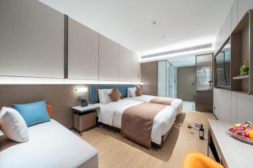 a hotel room with two beds and a couch at Yizhi Hotel - Guangzhou Shamian Island Huangsha Metro Station-Canton Fair free shuttle bus included Breakfast in Guangzhou