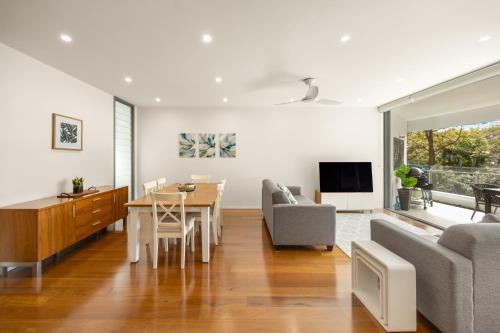 a living room with a table and a dining room at Riverside Lux 2Bed 2Bath Parking in Brisbane