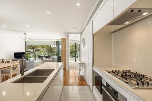 a kitchen with a sink and a stove top oven at Riverside Lux 2Bed 2Bath Parking in Brisbane