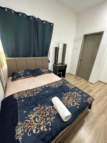 a bedroom with a bed with a blue and gold bedspread at Ayaan Snookers Home 3 at Quintet Apartment with Private Parking in Tanah Rata