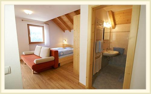a small room with a bed and a bathroom at Rungghof in La Valle
