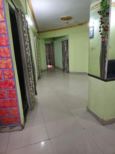 a corridor of a room with green walls and tile floors at Hotel Shristy Residency in Dhanbād