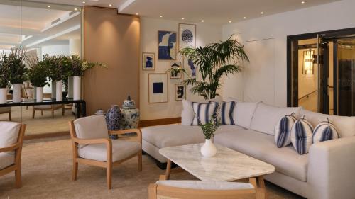 a living room with a white couch and chairs at Five Seas Cannes, a Member of Design Hotels™ in Cannes