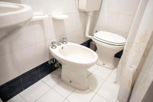 a white bathroom with a toilet and a sink at Appartamento G&G in Palmi