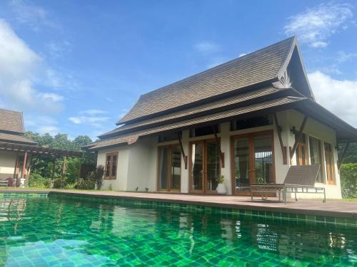 a house with a swimming pool in front of it at Villa Mae Hong Son in Mae Hong Son