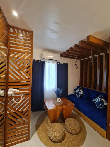a living room with a table and a blue couch at The Paragon Boracay Suites in Boracay