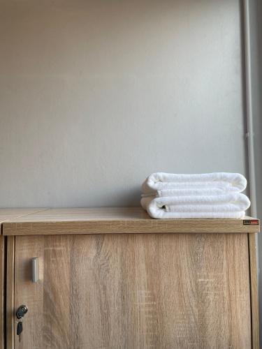 two white towels sitting on top of a wooden cabinet at Ti Thong Hostel in Bangkok