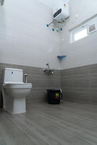 a bathroom with a toilet and a camera on the wall at Karur Homes in Kodaikānāl