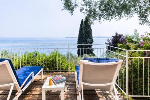 a patio with chairs and a table and a view of the ocean at Hotel Villa Florida & Suite Apartments in Gardone Riviera