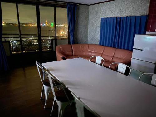 a room with a table and chairs and a couch at Kashibesso Kiteki - Vacation STAY 26650v in Kitakyushu