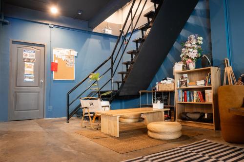 a blue room with a table and a staircase at Ti Thong Hostel in Bangkok