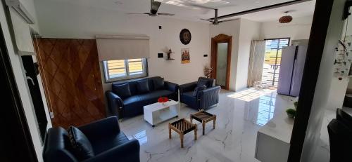 a living room with blue couches and a table at Suhana Aangan Rooms and Villa 