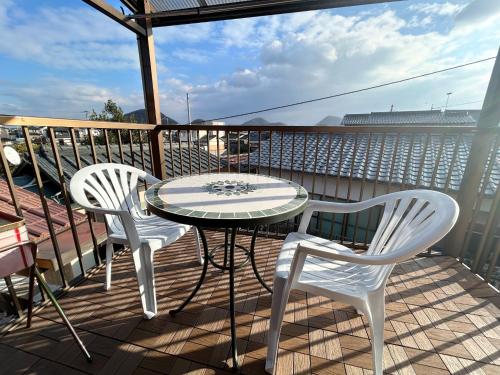 two white chairs and a table on a balcony at Classy Busshozan - Vacation STAY 15858 in Takamatsu