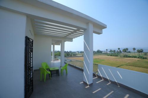 a balcony of a house with green chairs and a view at Suhana Aangan Rooms and Villa 