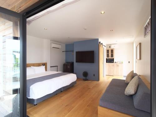 宫古岛HOTEL LOCAL BASE＜Miyakojima＞ - Vacation STAY 27035v的带床和沙发的卧室
