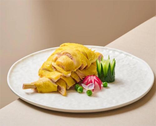 a white plate with a meal on a table at 郑州豪锦汇酒店 Zhengzhou Haojinhui Hotel in Zhengzhou