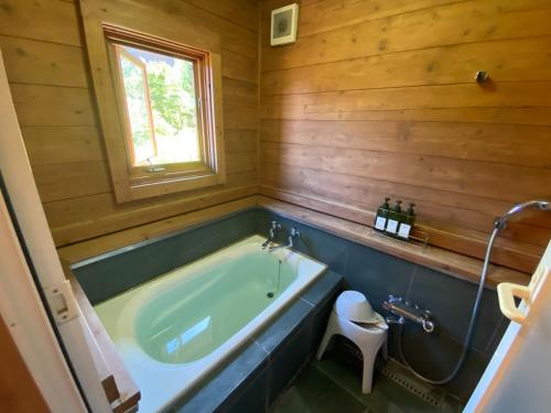 a bathroom with a green tub and a toilet at Spa&View COZY HOUSE - Vacation STAY 36902v in Okawa