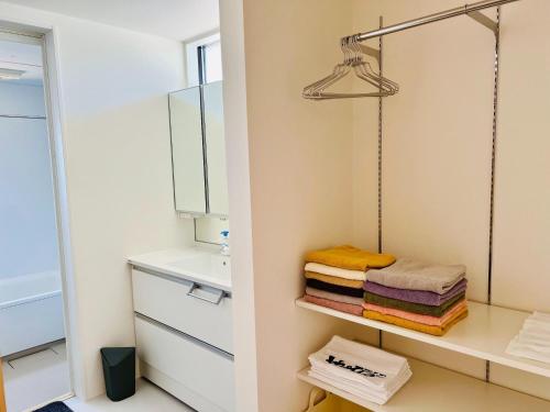 a bathroom with a sink and a mirror and towels at BHOLIC - Vacation STAY 15876 in Shimonoseki