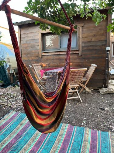 a hammock hanging in front of a cabin at תפארת עזך in Kefar H̱ananya