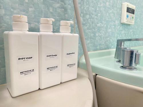 three white bottles sitting on top of a bath tub at Lights YADO Akasaki - Vacation STAY 15901 in Sasebo