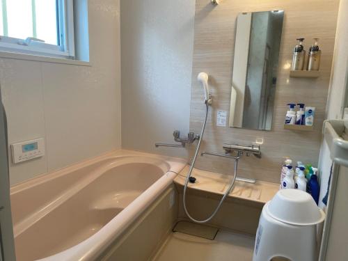 a bathroom with a bath tub with a blow dryer at Private sauna stay Shinori - Vacation STAY 34530v in Hakodate