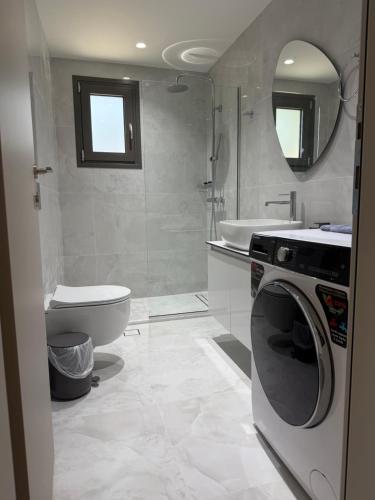 a bathroom with a washing machine and a toilet at Poseidon 77B Luxury Residences in Loutraki