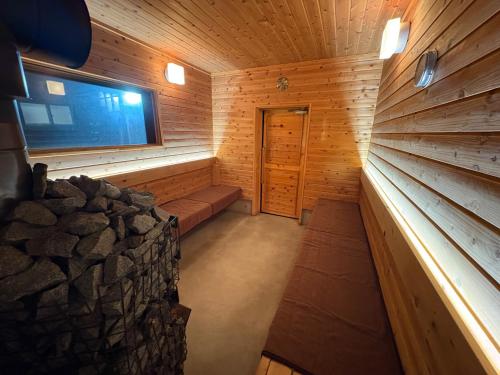 an empty sauna with a window and a stone wall at Private sauna stay Shinori - Vacation STAY 34530v in Hakodate